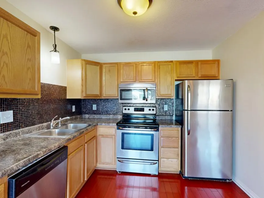 Contemporary kitchen featuring stainless steel appliances and wooden cabinetry.